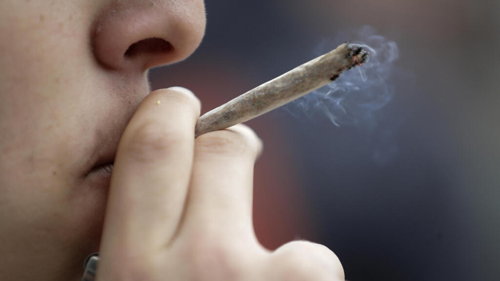 Un hombre consume marihuana durante una manifestación por la descriminalización del cannabis en París, Francia (12 de mayo 2018),