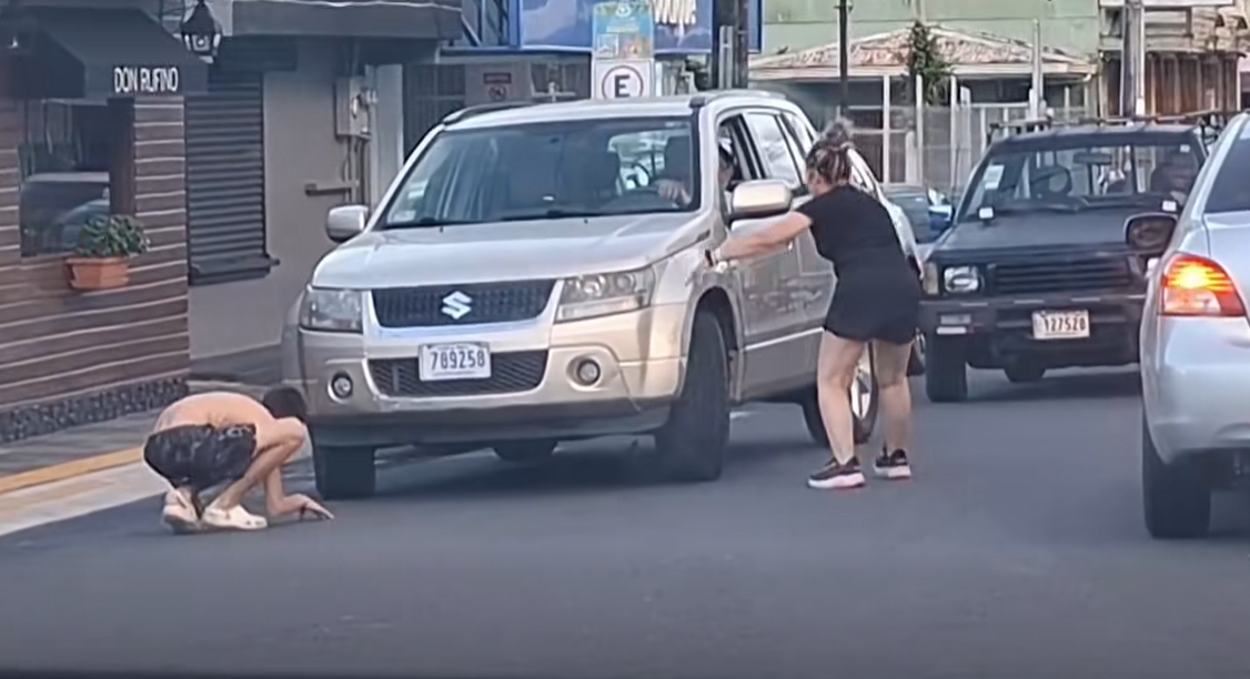 Menor y mujer detienen el tránsito por buscar desesperadamente a un pollito