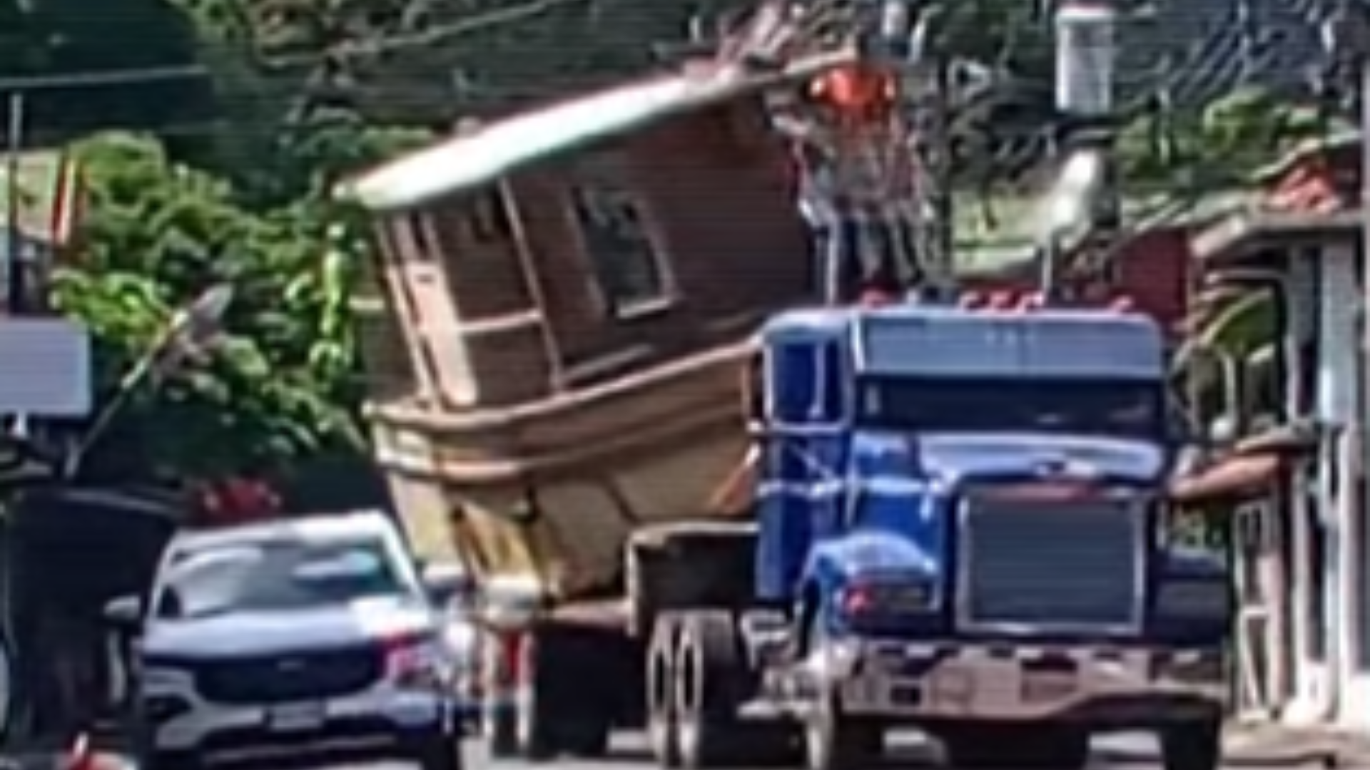 Insólito: Transportan barco en camión mientras dos sujetos apartan cables de luz en el techo